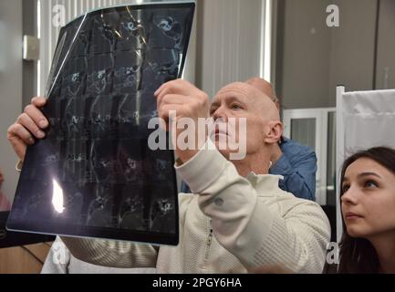 Lviv, Ukraine. 20th Mar, 2023. An American surgeon examines an X-ray of a patient in one of Lviv's hospitals. American specialists in plastic and maxillofacial surgery, cleft lip and palate, neurosurgeons, otolaryngologists, dermatologists, and urologists came to Lviv. Everyone who wanted to was able to sign up for appointments. Specialists consulted people with congenital and acquired defects, mine-explosive facial injuries and post-burn defects. Some patients underwent surgery after consultations. Credit: SOPA Images Limited/Alamy Live News Stock Photo