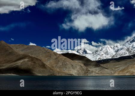 Looking up at Muztagh Tower, known as the father of glaciers, from Pamirs Karakul Lake Stock Photo