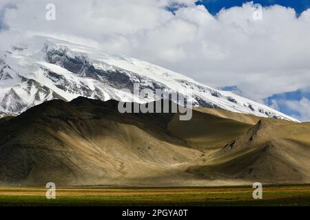 Looking up at Muztagh Tower, known as the father of glaciers, from Pamirs Karakul Lake Stock Photo