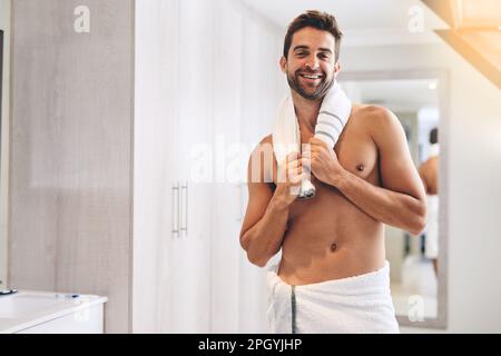 That shower was great. Cropped portrait of a handsome young man holding a towel around his neck in his bathroom at home. Stock Photo
