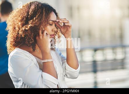 I just cant right now. an attractive young woman looking stressed while making a phone call outside. Stock Photo
