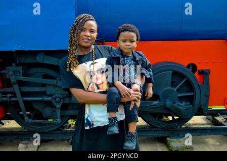 beautiful black mother carrying her son in her arms Stock Photo