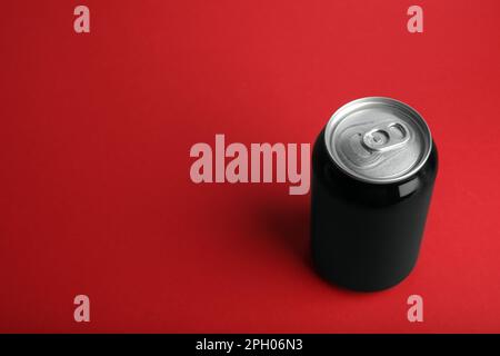 Black can of energy drink on red background. Space for text Stock Photo