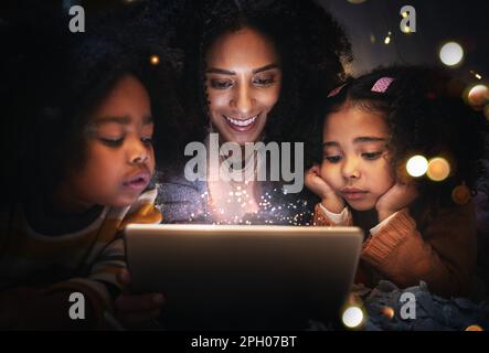 Tablet, night a woman reading to her children in a tent while camping in the bedroom of their home together. Black family, story or kids with a mother Stock Photo