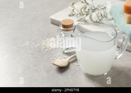 Glass jug with natural rice water on light grey table, closeup Stock ...