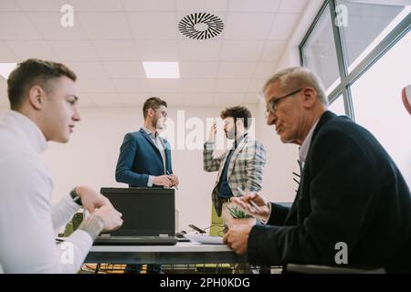 One of the two businessmen is disagreeing with the others offer in the office workspace Stock Photo