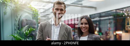 Two business people standing in office during break and looking camera. Teamwork concept Stock Photo