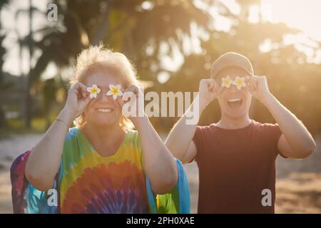 Funny portrait of happy senior woman with her adult son during travel in tropical destination. Stock Photo