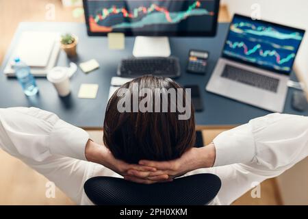 Businessman trading stocks online. Stock investor analysing numbers at graphs and charts. Investor planning and analysing stock market profiit. Man wo Stock Photo