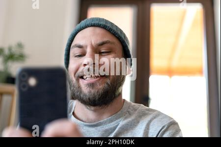 Millennials generation man using his smartphone for social media on internet at home. Stock Photo