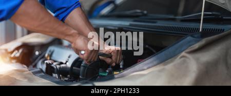 Close up technician uses multimeter voltmeter to check voltage level in car battery. Service and Maintenance car battery. Stock Photo