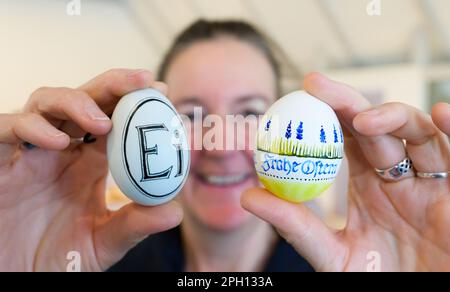 25 March 2023, Lower Saxony, Lübeln: Kirstin Rüter, artisan, holds eggs painted by her. At the traditional Easter egg market at the Rundlingsmuseum, Easter eggs of different types and sizes are on display, decorated and painted. Photo: Philipp Schulze/dpa Stock Photo