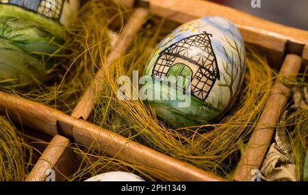 25 March 2023, Lower Saxony, Lübeln: A colorfully painted egg lies in a basket. At the traditional Easter egg market at the Rundling Museum, Easter eggs of different types and sizes are on display, decorated and painted. Photo: Philipp Schulze/dpa Stock Photo