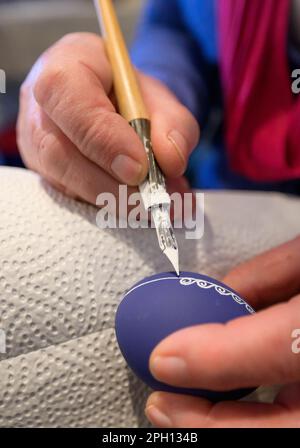 25 March 2023, Lower Saxony, Lübeln: An artisan paints an egg. At the traditional Easter egg market at the Rundling Museum, Easter eggs of different types and sizes are on display, decorated and painted. Photo: Philipp Schulze/dpa Stock Photo
