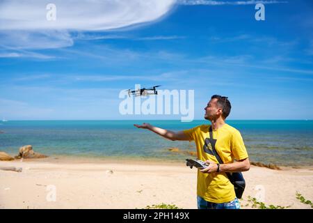 A guy launches from the arm of a prone on the seashore. Stock Photo