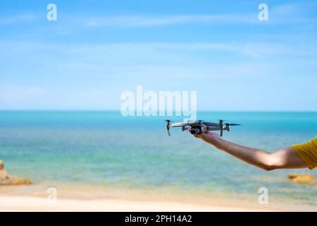 A guy launches from the arm of a prone on the seashore. Stock Photo