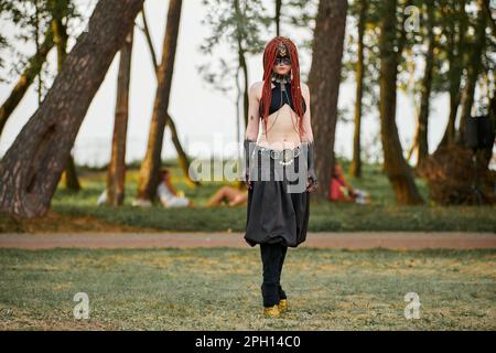 Mythological dancing girl faun on green lawn in public park outdoor art dancing event with mythological atmosphere. Girl in image of mythical creature Stock Photo