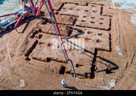 Concreting foundation of house using concrete pump by construction worker Stock Photo