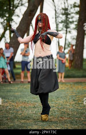 Mythological dancing girl faun on green lawn in public park outdoor art dancing event with mythological atmosphere. Girl in image of mythical creature Stock Photo