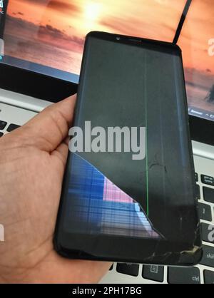 Hand holding smartphone with broken screen and lcd. Stock Photo