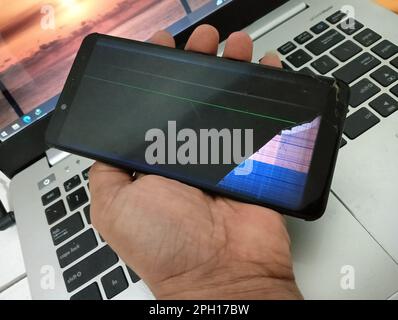 Hand holding smartphone with broken screen and lcd. Stock Photo