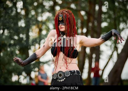 Mythological dancing girl faun on green lawn in public park outdoor art dancing event with mythological atmosphere. Girl in image of mythical creature Stock Photo