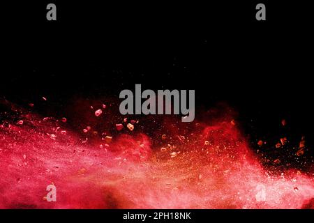 Split debris of  stone exploding with orange powder splash against black background. Stock Photo