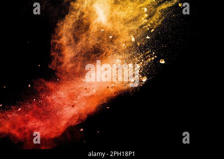 Split debris of  stone exploding with orange red powder splash against black background. Stock Photo