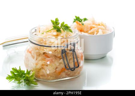 Sauerkraut with carrots and spices in a glass jar isolated on white background Stock Photo