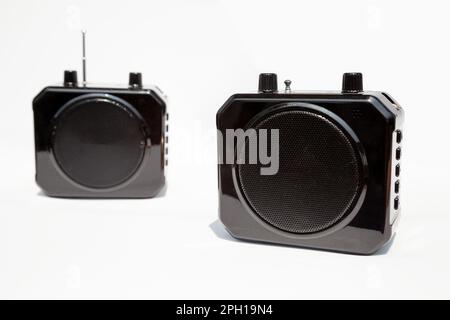 2 wireless mini voice amplifiers for teachers, coaches, tour guides and presentations. Portable black voice booster device isolated on white Stock Photo