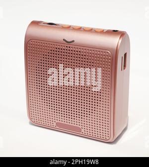 Wireless mini voice amplifier for teachers, coaches, tour guides and presentations. Portable pink voice booster device isolated on white Stock Photo