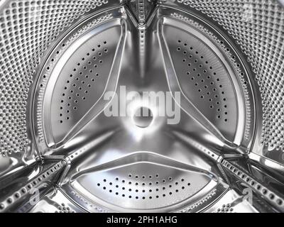 Washing machine drum close up. Washing machine background. Inside the washing machine. Metal washing machine drum. Perforated shiny metal Stock Photo