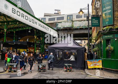 London, UK: Entrance to Borough Market on Stoney Street with the Market Porter pub and railway bridge. A famous and historical food market in London. Stock Photo