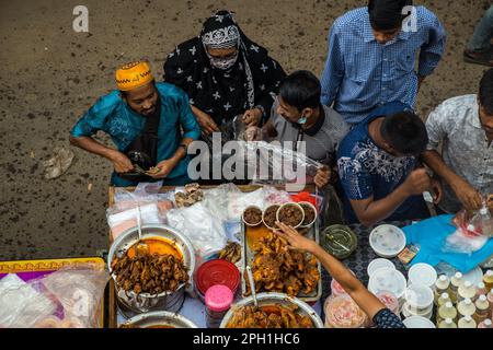 Bangladesh. 24th Mar, 2023. Bangladeshi vendors sell Iftar's items at Chawkbazar on the first day of the Muslim holy month of Ramadan. Every year a traditional Iftar market is open on this occasion for almost 400 years in Old Dhaka. (Photo by Md. Noor Hossain/Pacific Press) Credit: Pacific Press Media Production Corp./Alamy Live News Stock Photo