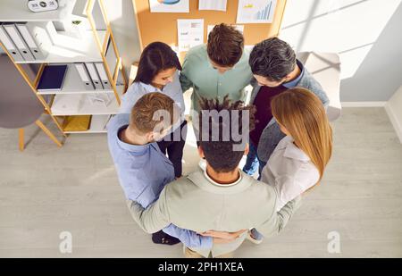 Team of young multiracial business men and women standing in a circle in the office Stock Photo
