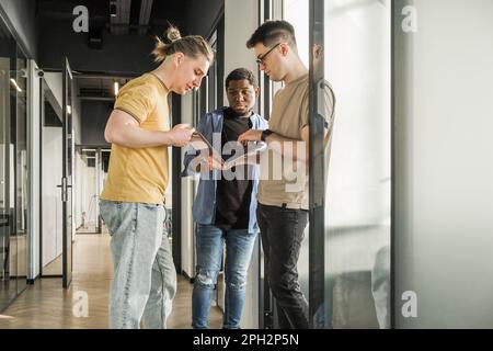A young developer gives new project tasks to his partners. Business people are discussing a new business project in the office. Coding technologies Stock Photo