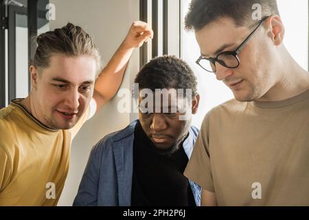 A young developer gives new project tasks to his partners. Business people are discussing a new business project in the office. Coding technologies Stock Photo