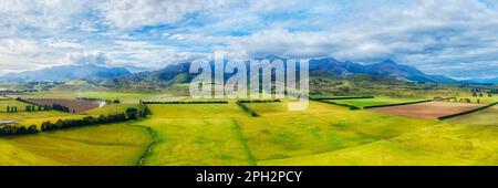 Aerial panorama at the key farm lands cultivated ship growing agriculture in New Zealand near Brunel peaks mountains. Stock Photo