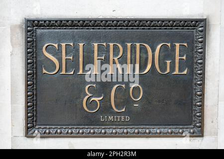 LONDON, UK, 10TH MARCH 2023: Brass company plaque on wall outside the historic Selfridges & Co. department store in London Stock Photo