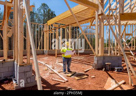Construction work is being carried out at building site by contractor using blueprint plan for architecture Stock Photo