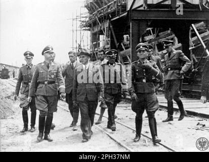 Heinrich Himmler (second left) visits the IG Farben plant in Auschwitz III concentration camp, July 1942. IG Farben built their synthetic rubber factory here as the site had good railway connections and access to raw materials as well as a huge pool of unpaid workers. Stock Photo