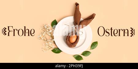 Plate, Easter egg wrapped in napkin and text FROHE OSTERN (Happy Easter in German) on light color background Stock Photo