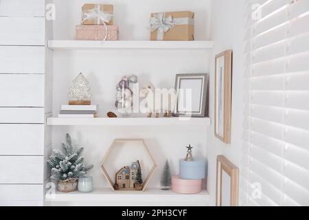 Wall shelves with beautiful Christmas decor indoors. Interior design Stock Photo
