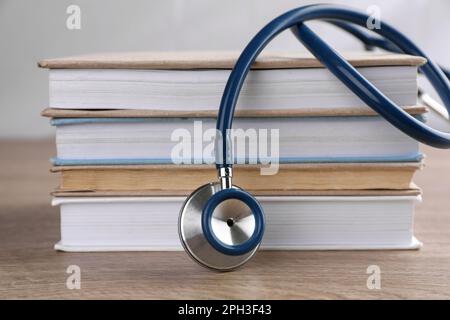 Stack of student textbooks and stethoscope on white background. Medical ...