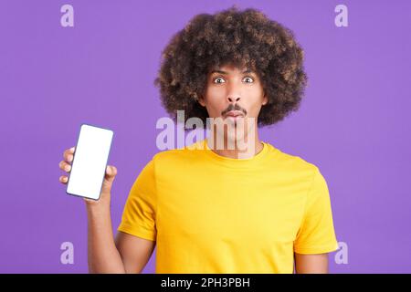 Surprised african man holding a mobile with a blank screen Stock Photo