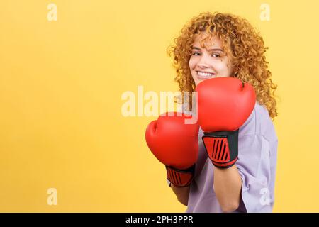Portrait of confident young woman wearing red boxing gloves and