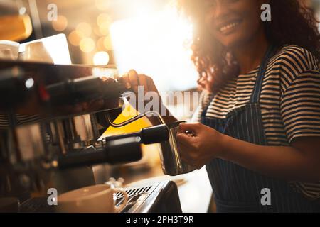 Your perfect brew is on its way. Closeup shot of a barista operating a coffee machine in a cafe. Stock Photo
