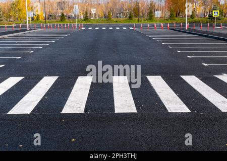 The white and yellow lines of the pedestrian crossing at the intersection of roads in the city. Road safety. Zebra road markings, crossing point of th Stock Photo