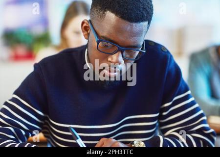 Hes always been a focused and diligent student. a university student working in class at campus. Stock Photo