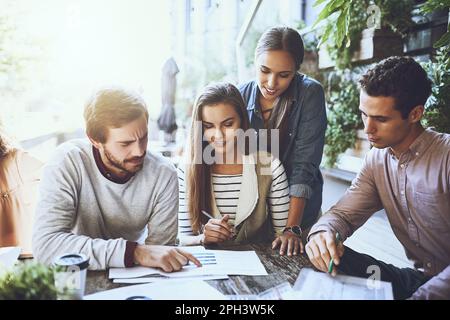 Doing business out in the open. a group of colleagues having a meeting at a cafe. Stock Photo